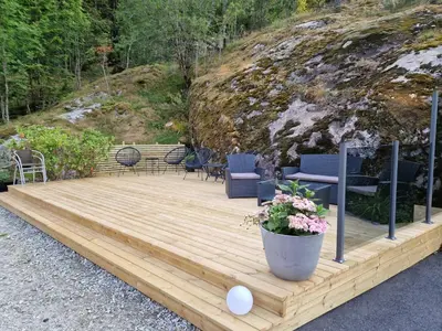 a wooden deck with chairs and a table at Kvamsdal Pensjonat 2 in Eidfjord