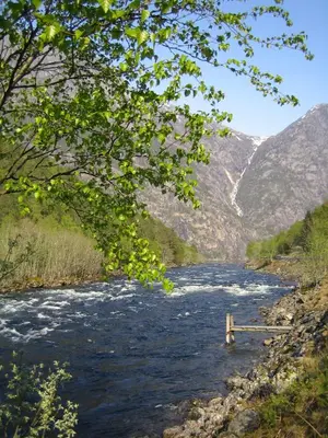 a view of a river with mountains in the background at Kvamsdal Pensjonat 2 in Eidfjord
