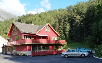 a red house with a car parked in front of it at Kvamsdal Pensjonat 2 in Eidfjord