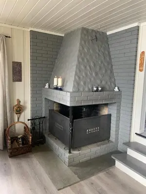 a brick fireplace with candles in a living room at Halsteinsplassen in Surteberg