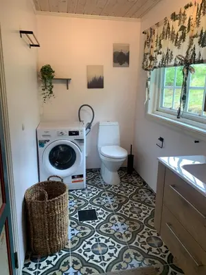 a bathroom with a washing machine and a toilet at Halsteinsplassen in Surteberg