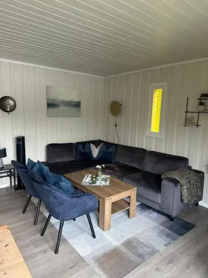 a living room with a black couch and a table at Halsteinsplassen in Surteberg