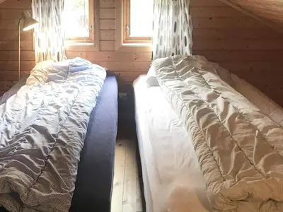 a bedroom with two beds in a log cabin at 6 person holiday home in Espevær-By Traum in Espevær