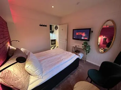 a bedroom with a bed and a mirror and a television at Rødseth gårdsovernatting Dobbeltrom in Molde