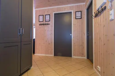 a hallway with a door in a room with wooden walls at In the middle of Trysil fjellet - Welcome Center - Apartment with 4 bedrooms and sauna - By bike arena and ski lift in Trysil