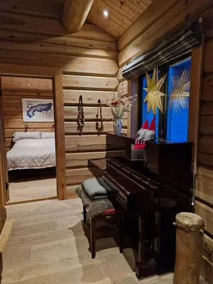 a bedroom with a piano in a room with a bed at Liaplassen Timber Lodge in Beitostøl