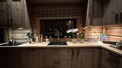 a kitchen with wooden cabinets and a sink and a window at Liaplassen Timber Lodge in Beitostøl
