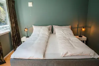 a bed with white sheets and pillows in a bedroom at Vestly in Etnesjøen