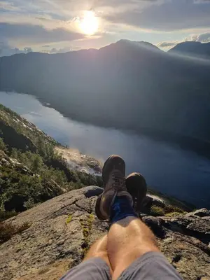 a person sitting on top of a rock with a dog at Langfoss in Etnesjøen