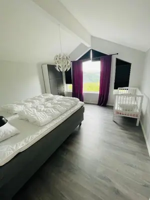 a bedroom with a large bed and a window at Fosskamben 1 Moderne hytte ikkje langt frå Sogndal in Sogndal