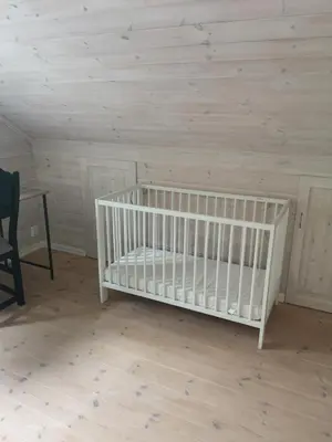 a crib in a room with a wooden ceiling at Casa Kleiv i Sogndalsdalen in Sogndal