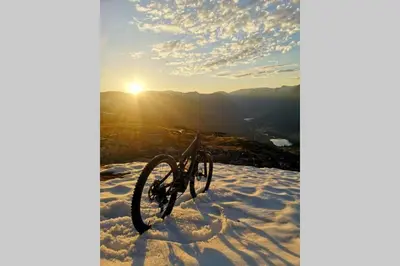 a bike in the snow with the sun in the background at Casa Kleiv i Sogndalsdalen in Sogndal