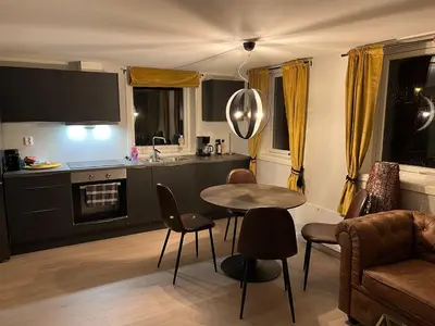 a kitchen and living room with a table and chairs at Atlantic Panorama Villa Kalle in Kristiansund