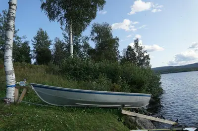 a boat parked on the shore of a lake at Luxury Norwegian Cottage in Hurdal