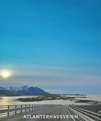 a road in the desert with mountains in the background at Rødseth Gårdsovernatting Familierom in Molde
