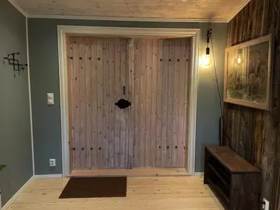 a large wooden door in a room with a wall at Stall-loftet, Aastrøen gård, Vingelen in Vingelen