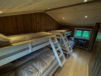 a room with three bunk beds in a cabin at Stall-loftet, Aastrøen gård, Vingelen in Vingelen