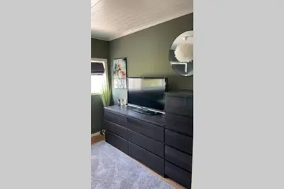 a living room with a television and a dresser at Townhouse with fantastic outdoor area in Trondheim