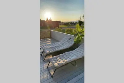 a deck with two chairs and a bench on it at Townhouse with fantastic outdoor area in Trondheim