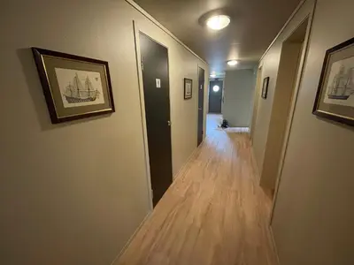 a hallway with two doors and a wooden floor at Gjøa Motell in Rosendal