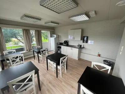 a kitchen and dining room with tables and chairs at Gjøa Motell in Rosendal