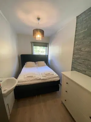 a small bedroom with a bed and a sink at Kvamseter Lodge private family apartment in Kvam