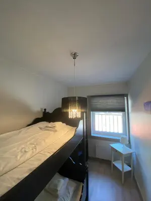 a bedroom with a bed and a chandelier at Kvamseter Lodge private family apartment in Kvam