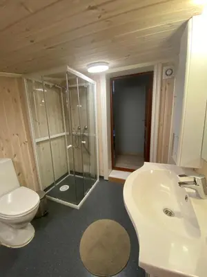 a bathroom with a toilet and a sink and a shower at Kvamseter Lodge private family apartment in Kvam