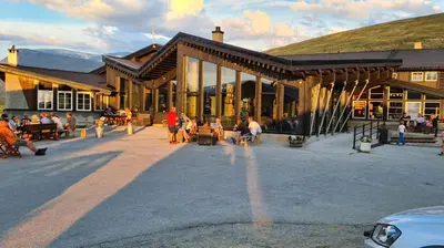 a group of people sitting outside of a building at Raubergstulen fjellstue og hytter in Boverdalen