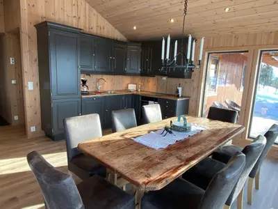 a dining room with a wooden table and chairs at Løstegård Cabins in Gol