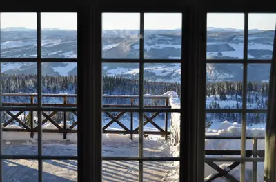 a view of a snowy mountain through a window at Løstegård Cabins in Gol