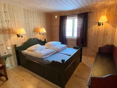 a bedroom with a bed with two pillows on it at Løstegård Cabins in Gol