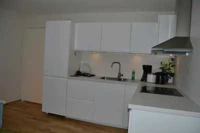 a white kitchen with white cabinets and a sink at Totally independent apartment near NTNU,Lerkendal and Center in Trondheim