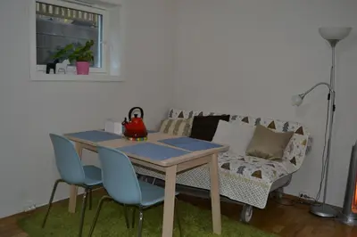 a table and chairs in a living room with a couch at Totally independent apartment near NTNU,Lerkendal and Center in Trondheim