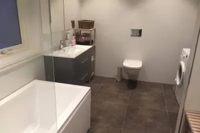 a bathroom with a tub and a sink and a toilet at Austefjordtunet 15 in Forland
