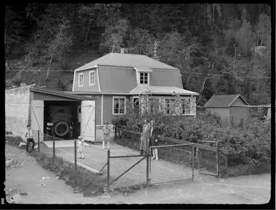 a black and white photo of a house with people standing outside at Villa Rjukan in Rjukan