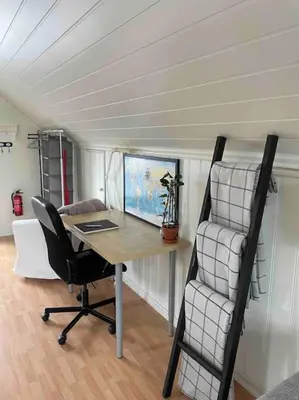 a desk and a chair in a tiny house at Koselig garasjeloft! in Holen