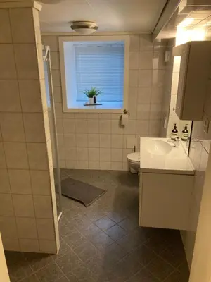 a bathroom with a sink and a toilet and a window at Kjellerleilighet - nært Haukeland sykehus. in Bergen