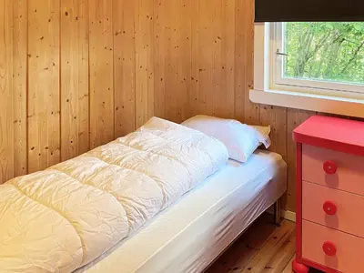 a small bedroom with a bed and a window at 4 person holiday home in Reksteren-By Traum in Klinkholmen
