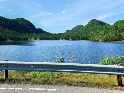 a bench sitting on the side of a lake at 4 person holiday home in Reksteren-By Traum in Klinkholmen