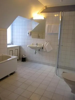 a bathroom with a tub and a sink and a shower at Hjelle Hotel in Hjelle