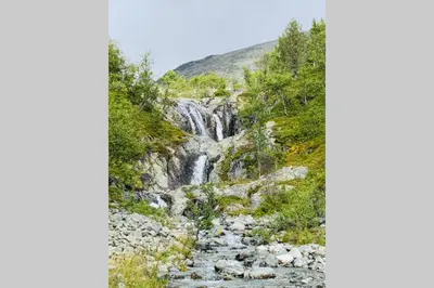 a waterfall on the side of a mountain at Super sentral, flott og solrik leilighet i sentrum in Hemsedal