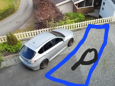 a white car parked in a driveway next to a house at Espeland in Bergen