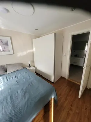 a bedroom with a bed and a white refrigerator at Espeland in Bergen