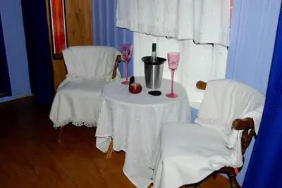a table with two chairs and two glasses of wine at Regnbuegården in Røros