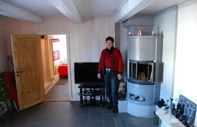 a man standing in a room with a television at Regnbuegården in Røros