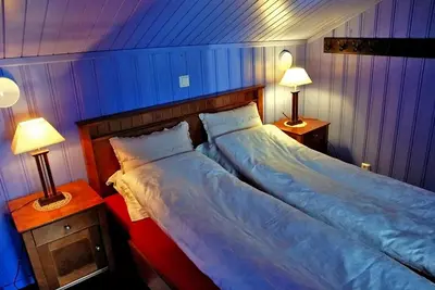 a bedroom with two beds and two lamps on tables at Regnbuegården in Røros