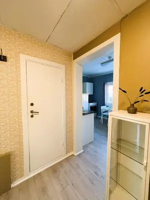 an empty room with a door and a kitchen at Lillehammer Camping - Sentrums leilighet in Lillehammer