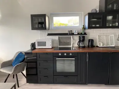 a kitchen with black cabinets and a counter top at Feriehus med Sjøutsikt in Sætra