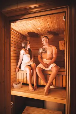 a man and a woman sitting in a sauna at Skiers Lodge 2 - Saga Apartments in Hemsedal
